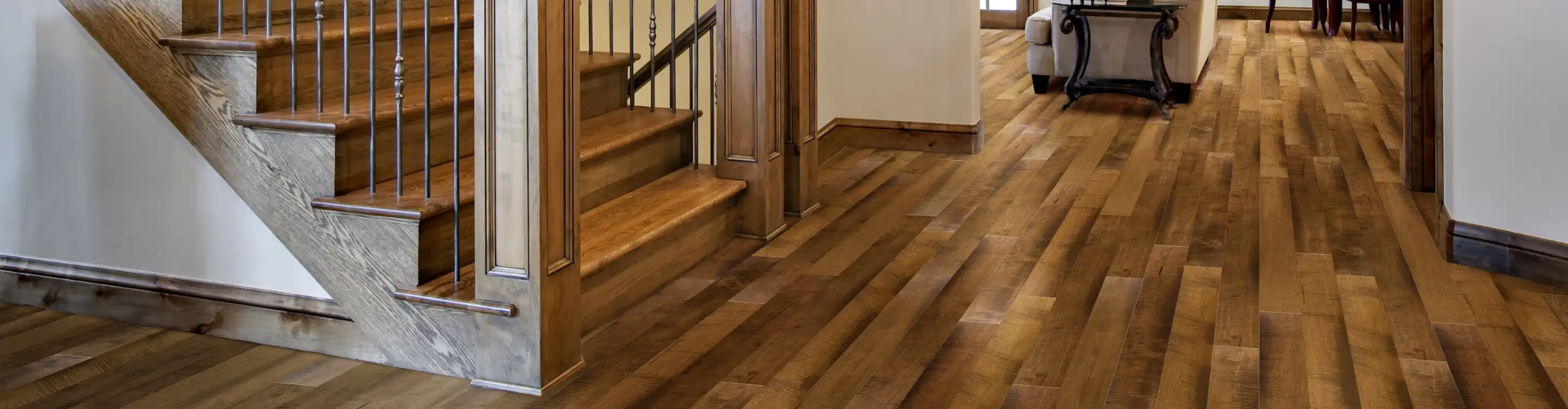 Dark, freshly stained hardwood flooring in entryway with staircase. 